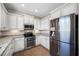 Modern kitchen with stainless steel appliances, white cabinetry, and tiled floors at 4943 Grand Oak Cir, Madeira Beach, FL 33708