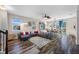 Open living room with L-shaped sectional sofa, wood floors, and access to dining area at 4943 Grand Oak Cir, Madeira Beach, FL 33708