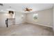 Open loft area featuring neutral paint, a ceiling fan, two windows with blinds, and a decorative pendant light at 4943 Grand Oak Cir, Madeira Beach, FL 33708