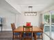 Charming dining room with a wooden table, four chairs, and a modern light fixture at 8304 Sandstone Ct, Tampa, FL 33615