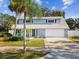 Charming two-story home with gray exterior, landscaping, and a two-car garage at 8304 Sandstone Ct, Tampa, FL 33615