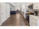 Long kitchen with white cabinets, stainless steel appliances, and hardwood floors at 8304 Sandstone Ct, Tampa, FL 33615