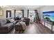 Spacious living room featuring a large sectional sofa, hardwood floors, and a mounted TV at 8304 Sandstone Ct, Tampa, FL 33615