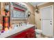 Bathroom with red vanity, white fixtures, and unique decor at 1130 Barranca Ave, Spring Hill, FL 34609