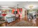 Open living space with hardwood floors, a red accent wall, and ample natural light at 1130 Barranca Ave, Spring Hill, FL 34609