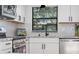 Modern kitchen with white cabinets, herringbone backsplash and a black faucet at 13182 72Nd Ter, Seminole, FL 33776