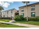 Tan condo building with lush landscaping and walkway at 19725 Gulf Blvd # 46, Indian Shores, FL 33785