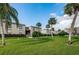 Condo building with palm trees and a well-maintained lawn at 19725 Gulf Blvd # 46, Indian Shores, FL 33785