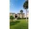 Two story condo building with palm trees and grassy lawn at 19725 Gulf Blvd # 46, Indian Shores, FL 33785