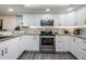 Bright kitchen with white cabinets, granite counters, and stainless steel appliances at 19725 Gulf Blvd # 46, Indian Shores, FL 33785