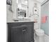 Clean bathroom with dark vanity, marble countertop, and a shower at 200 Glennes Ln # 206, Dunedin, FL 34698