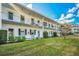Two-story building with balconies, green accents, and manicured lawn at 200 Glennes Ln # 206, Dunedin, FL 34698