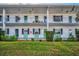 Two-story building with balconies, green accents, and manicured lawn at 200 Glennes Ln # 206, Dunedin, FL 34698