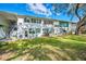 White building with green accents, grassy yard, and a bicycle at 200 Glennes Ln # 206, Dunedin, FL 34698