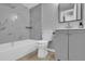 Bathroom featuring a tiled bathtub, matching grey vanity, toilet, and updated fixtures at 209 Red Cedar Pl # 209, Brandon, FL 33510