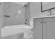 Modern bathroom with tiled bathtub, matching grey vanity, toilet, and updated fixtures at 209 Red Cedar Pl # 209, Brandon, FL 33510