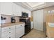 White kitchen with black appliances and tile backsplash at 2900 Gulf Blvd # 212, Belleair Beach, FL 33786