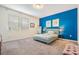 Spacious bedroom with a teal accent wall and carpeted floor at 2919 Grand Kemerton Pl, Tampa, FL 33618