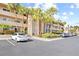 Condo building with palm trees and parking spaces at 3400 Gulf Blvd # 105, Belleair Beach, FL 33786