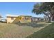 House backyard view, yellow house, green grass at 5430 Palm Crest N Ct, Pinellas Park, FL 33782