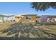 Backyard view, yellow house, green grass, and trees at 5430 Palm Crest N Ct, Pinellas Park, FL 33782