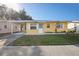 Adorable yellow house with carport and well-maintained landscaping at 5430 Palm Crest N Ct, Pinellas Park, FL 33782
