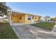 Front view of a yellow house with carport and small yard at 5430 Palm Crest N Ct, Pinellas Park, FL 33782
