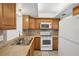 Kitchen features wood cabinets, tile backsplash, and white appliances at 5430 Palm Crest N Ct, Pinellas Park, FL 33782
