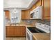 Kitchen boasts wood cabinets, tile backsplash and white appliances at 5430 Palm Crest N Ct, Pinellas Park, FL 33782