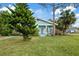 Light blue house with a front yard, and palm trees at 6609 N Elizabeth St, Tampa, FL 33604