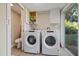 Bright laundry room, features washer, dryer, storage cabinets and tile flooring at 6609 N Elizabeth St, Tampa, FL 33604