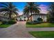 Luxury home exterior at dusk, showcasing landscaping and brick driveway at 15908 Castle Park Ter, Lakewood Ranch, FL 34202