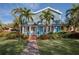 Charming blue house with brick pathway, lush landscaping, and palm trees at 165 21St Ne Ave, St Petersburg, FL 33704
