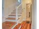Staircase with hardwood steps and white wainscoting, leading to the upper level, with a view of the bathroom at 165 21St Ne Ave, St Petersburg, FL 33704
