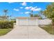 Two-car garage with white doors and a long concrete driveway at 204 163Rd Ave, Redington Beach, FL 33708