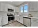 Modern kitchen with white cabinets, stainless steel appliances, and quartz countertops at 3442 Desert Trunk Ct, Tampa, FL 33614