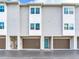 Row of townhomes with teal doors and brown garage doors at 521 Pinellas Bayway S # 107, St Petersburg, FL 33715