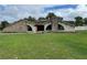 Stone exterior house with large windows and a spacious lawn at 5404 Glover Dr, Weeki Wachee, FL 34607