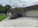 Attached garage with large driveway and pink crape myrtle at 5404 Glover Dr, Weeki Wachee, FL 34607