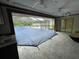 Screened-in pool area with a pool cover and a partially visible house at 5404 Glover Dr, Weeki Wachee, FL 34607