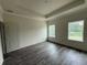 A bedroom with new dark laminate flooring has two windows and a trey ceiling at 5725 Desert Rose Pl, Tampa, FL 33615