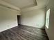 A bedroom with new dark laminate flooring has two windows and a trey ceiling at 5725 Desert Rose Pl, Tampa, FL 33615