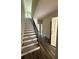 A light-filled home entryway featuring wood-look flooring, stairs to the upper level, and a view of an open hallway at 5725 Desert Rose Pl, Tampa, FL 33615