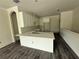A spacious kitchen boasts sleek white cabinets, quartz countertops, and a large island perfect for entertaining at 5725 Desert Rose Pl, Tampa, FL 33615