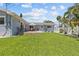 Well-maintained backyard with a seating area, spacious lawn, and pristine white fencing at 709 Mandalay Ave, Clearwater Beach, FL 33767