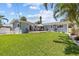 Beautiful backyard featuring a lush lawn, patio area, and tropical landscaping at 709 Mandalay Ave, Clearwater Beach, FL 33767
