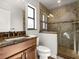 Bathroom features a granite countertop, wood cabinets, and a glass shower with beige tiling at 709 Mandalay Ave, Clearwater Beach, FL 33767