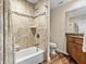 Bathroom featuring tub, shower, tiled walls, wood cabinets, and a granite vanity at 709 Mandalay Ave, Clearwater Beach, FL 33767