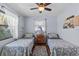 Charming bedroom featuring wood floors, twin beds, ceiling fan, and lots of natural light at 709 Mandalay Ave, Clearwater Beach, FL 33767