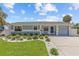 A charming single-story home featuring a driveway with manicured front yard landscaping at 709 Mandalay Ave, Clearwater Beach, FL 33767